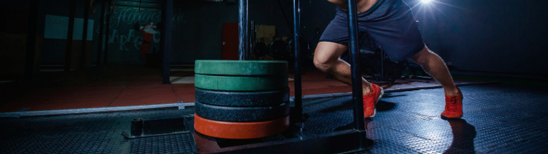 nexo_man pushing sled at gym